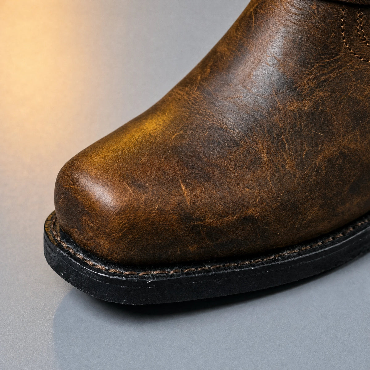 Square toe close-up on cognac brown harness boot