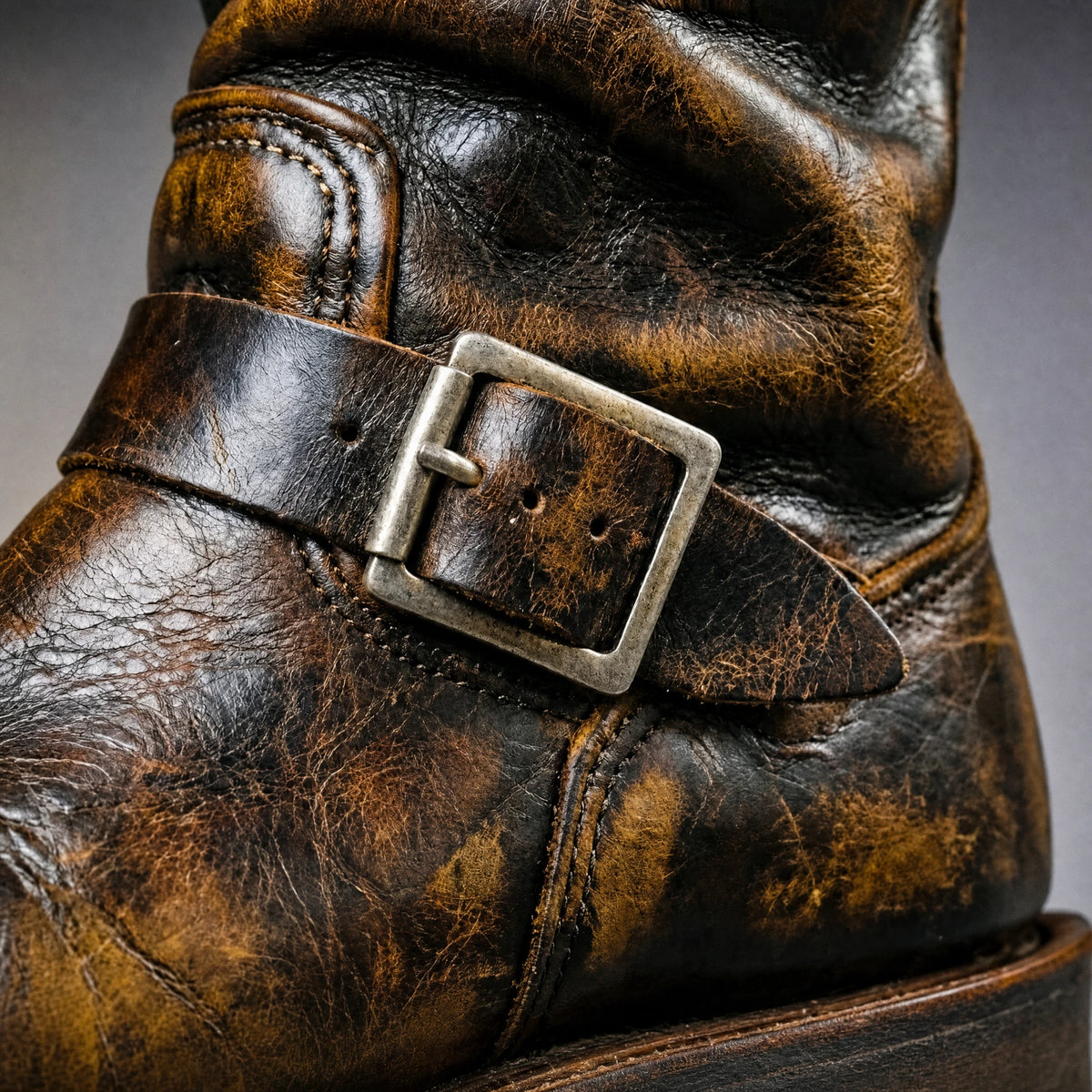 Buckle strap close-up on distressed vintage brown engineer boot